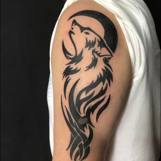 Tribal wolf howling at moon tattoo designs on shoulder
