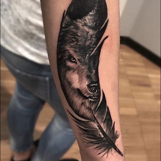 wolf and feather tattoo design on forearm
