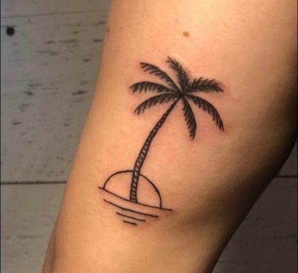 beautiful palm tree tattoo on thigh