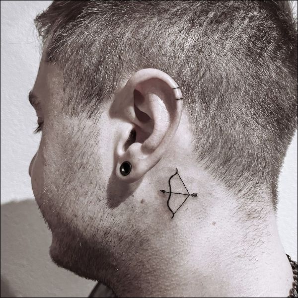 bow and arrow behind the ear tattoos